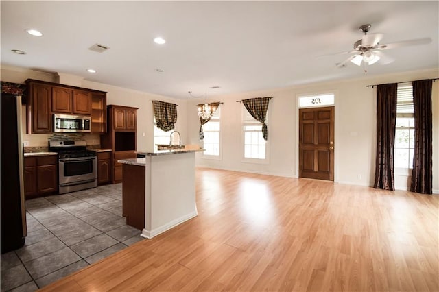 105 Norton Ave, Arabi, LA 70032 - kitchen with stainless steel appliances, ceiling fan, a center island with sink, light wood finished floors, and recessed lighting