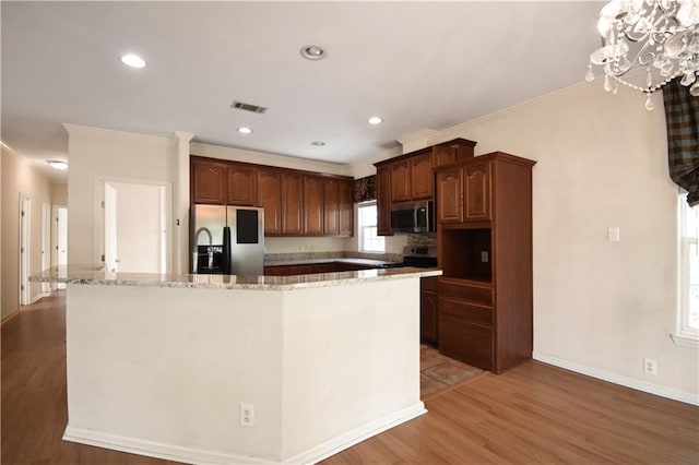 105 Norton Ave, Arabi, LA 70032 - kitchen featuring stainless steel appliances, light wood finished floors, ornamental molding, a large island, and light stone counters