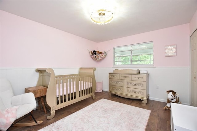 206 Loop Dr, Slidell, LA 70458 - bedroom featuring wainscoting, wood finished floors, and a crib