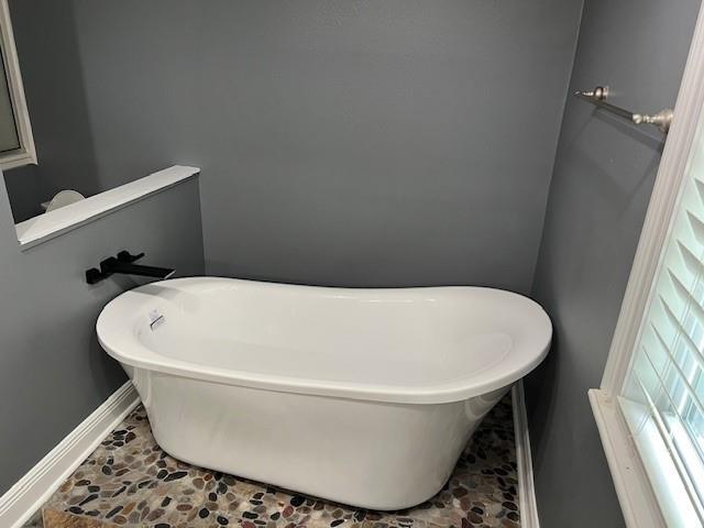 115 Devereux Dr, Slidell, LA 70461 - bathroom with a freestanding tub, baseboards, and stone finish floors