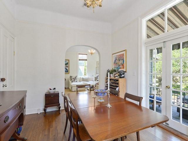 39294 Broadway St, New Orleans, LA 70118 - dining area with a chandelier, arched walkways, dark wood-style flooring, and baseboards