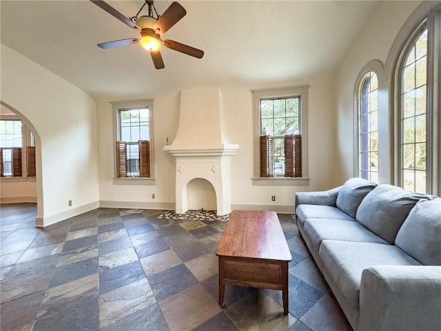 2508 Joseph St, New Orleans, LA 70115 - living room with baseboards, arched walkways, a ceiling fan, and vaulted ceiling
