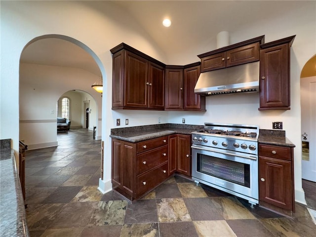 2508 Joseph St, New Orleans, LA 70115 - kitchen with under cabinet range hood, high end stove, stone tile floors, arched walkways, and baseboards