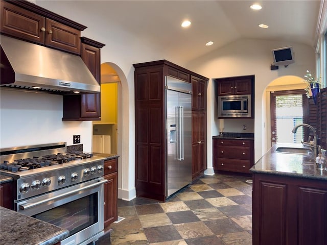 2508 Joseph St, New Orleans, LA 70115 - kitchen with built in appliances, arched walkways, under cabinet range hood, a sink, and vaulted ceiling