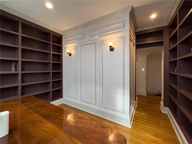 2508 Joseph St, New Orleans, LA 70115 - interior space featuring built in shelves, a decorative wall, ornamental molding, light wood-type flooring, and baseboards
