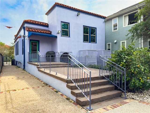 2508 Joseph St, New Orleans, LA 70115 - back of house featuring a tiled roof and stucco siding