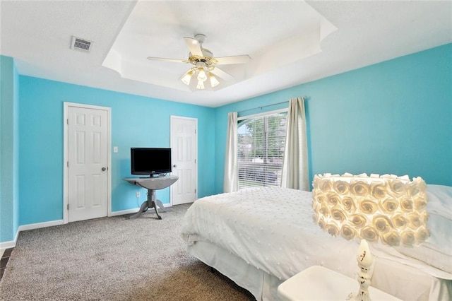 2986 Camellia Dr, Slidell, LA 70458 - carpeted bedroom with baseboards, a tray ceiling, and a ceiling fan