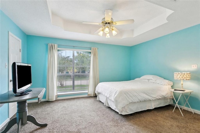 2986 Camellia Dr, Slidell, LA 70458 - carpeted bedroom featuring a raised ceiling, baseboards, ceiling fan, and a desk