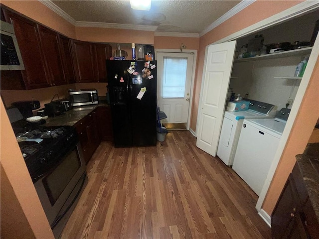 3034 Clouet St, New Orleans, LA 70126 - kitchen with black fridge, gas range oven, stainless steel microwave, separate washer and dryer, and light wood-style floors