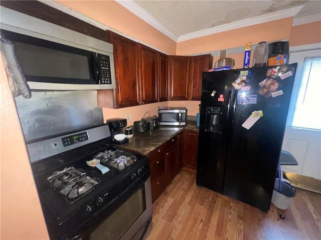 3034 Clouet St, New Orleans, LA 70126 - kitchen with stainless steel appliances, ornamental molding, and light wood finished floors
