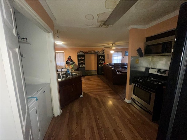 3034 Clouet St, New Orleans, LA 70126 - kitchen featuring appliances with stainless steel finishes, independent washer and dryer, a sink, dark wood-type flooring, and ceiling fan