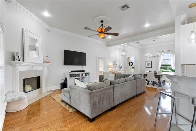 103 Lac Cypriere Dr, Luling, LA 70070 - living area with a ceiling fan, light wood finished floors, crown molding, a chandelier, and a tiled fireplace