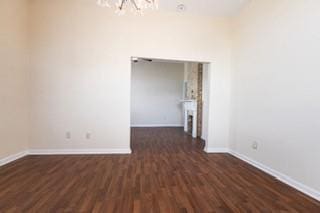 181113 Aubry St, New Orleans, LA 70116 - empty room featuring a chandelier, dark wood-type flooring, and baseboards