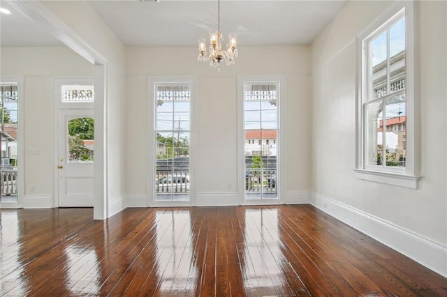 4628 Cleveland Ave, New Orleans, LA 70119 - unfurnished dining area with dark wood-style floors, a chandelier, and baseboards