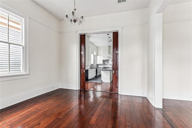 4628 Cleveland Ave, New Orleans, LA 70119 - unfurnished dining area with dark wood-style floors, a chandelier, and baseboards