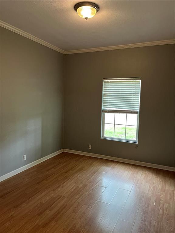 42984 River Birch Ln, Franklinton, LA 70438 - unfurnished room featuring wood finished floors, baseboards, and ornamental molding