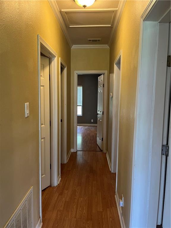 42984 River Birch Ln, Franklinton, LA 70438 - corridor featuring ornamental molding, attic access, and wood finished floors