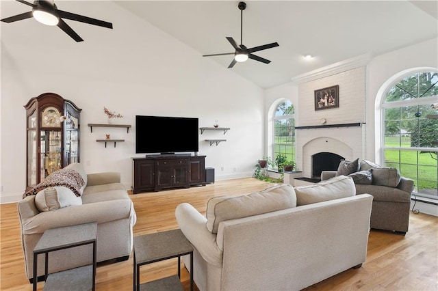 733 Plantation Dr, Abita Springs, LA 70420 - living room with a ceiling fan, high vaulted ceiling, healthy amount of natural light, a brick fireplace, and light wood-style floors