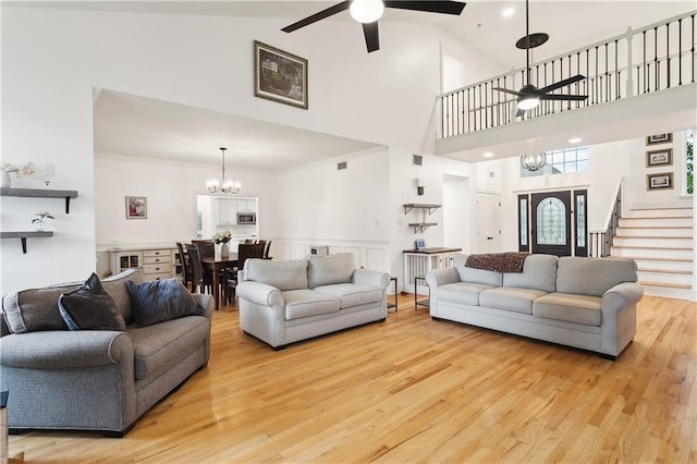 733 Plantation Dr, Abita Springs, LA 70420 - living area with a ceiling fan, a chandelier, a high ceiling, wood finished floors, and stairs