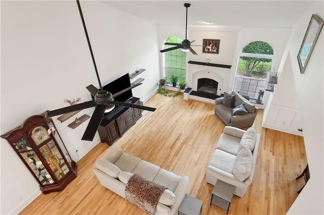 733 Plantation Dr, Abita Springs, LA 70420 - living area featuring a ceiling fan, wood finished floors, a large fireplace, and baseboards