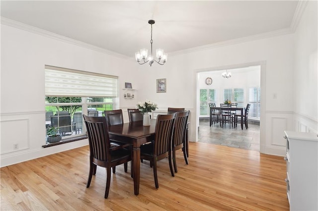 733 Plantation Dr, Abita Springs, LA 70420 - dining area with a chandelier, crown molding, a wainscoted wall, light wood finished floors, and a decorative wall