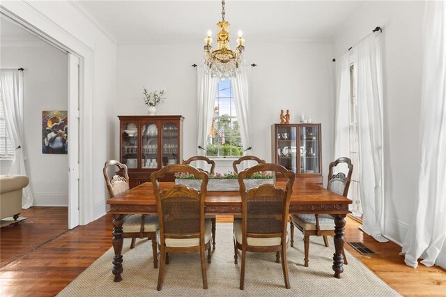 2728 Bell St, New Orleans, LA 70119 - dining area featuring a chandelier, wood finished floors, and ornamental molding