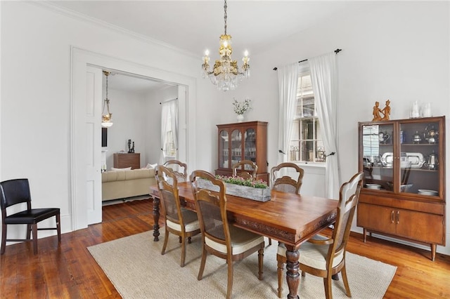 2728 Bell St, New Orleans, LA 70119 - dining space featuring healthy amount of natural light, a chandelier, wood finished floors, and ornamental molding