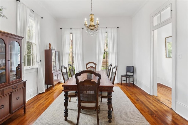 2728 Bell St, New Orleans, LA 70119 - dining area featuring a chandelier, healthy amount of natural light, wood-type flooring, and baseboards