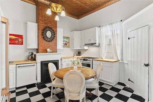 2728 Bell St, New Orleans, LA 70119 - kitchen with stainless steel stove, dark floors, white dishwasher, under cabinet range hood, and white cabinetry