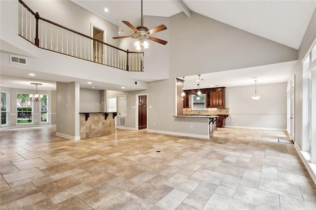 102 Ayshire Ct, Slidell, LA 70461 - unfurnished living room featuring a chandelier, high vaulted ceiling, ceiling fan, stone tile flooring, and baseboards