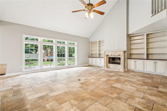 102 Ayshire Ct, Slidell, LA 70461 - unfurnished living room featuring high vaulted ceiling, baseboards, built in shelves, ceiling fan, and stone tile floors