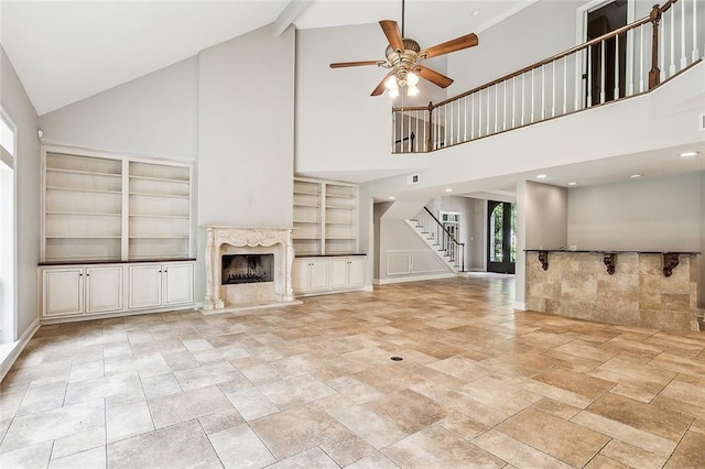 102 Ayshire Ct, Slidell, LA 70461 - unfurnished living room with high vaulted ceiling, stairway, ceiling fan, a premium fireplace, and stone tile flooring