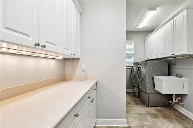 102 Ayshire Ct, Slidell, LA 70461 - laundry area featuring independent washer and dryer, cabinet space, baseboards, and stone finish flooring