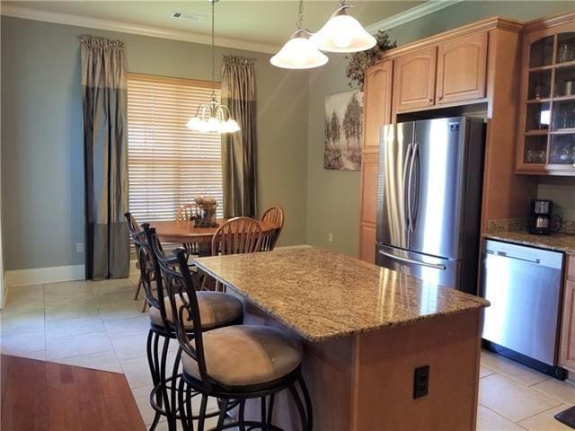 270 Nicklaus Dr, Slidell, LA 70458 - kitchen with stainless steel appliances, crown molding, a kitchen island, light stone countertops, and glass insert cabinets
