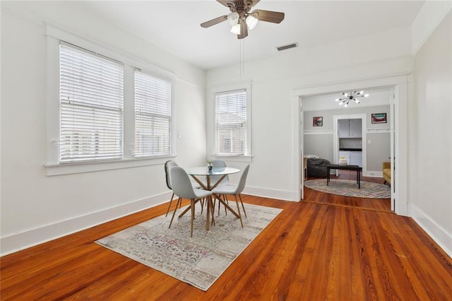 2933 Calhoun St Unit 2933, New Orleans, LA 70118 - dining space with ceiling fan, baseboards, wood finished floors, and a chandelier