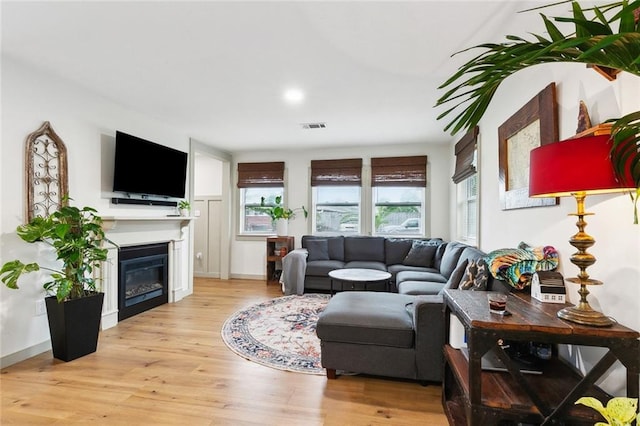 2405 Mariette Dr, Chalmette, LA 70043 - living area with wood finished floors, a glass covered fireplace, and recessed lighting