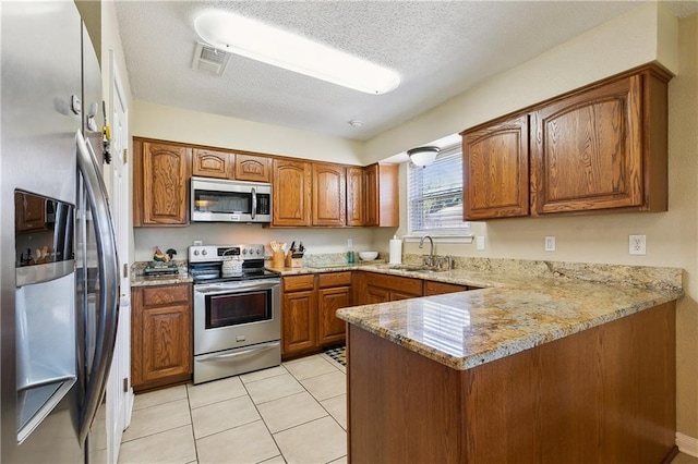3121 Arbutus Ln, Marrero, LA 70072 - kitchen with stainless steel appliances, a sink, brown cabinets, a peninsula, and light stone countertops