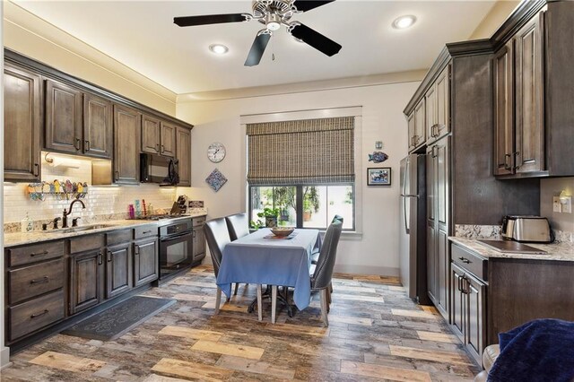 500 Tallow Tree Dr, Madisonville, LA 70447 - kitchen featuring a sink, black appliances, dark brown cabinets, wood finished floors, and recessed lighting