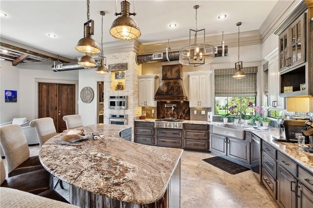 500 Tallow Tree Dr, Madisonville, LA 70447 - kitchen featuring premium range hood, appliances with stainless steel finishes, a sink, a breakfast bar, and tasteful backsplash