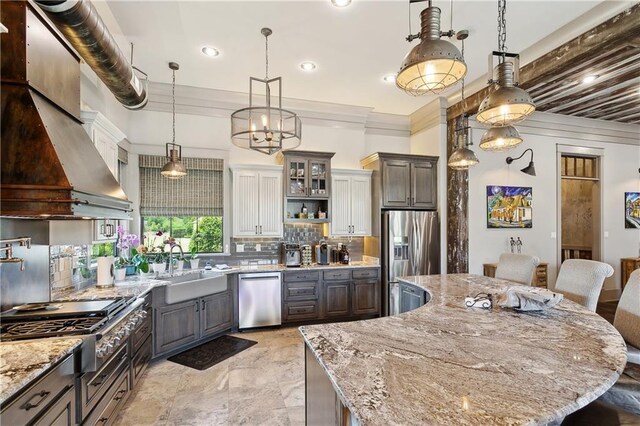 500 Tallow Tree Dr, Madisonville, LA 70447 - kitchen with stainless steel appliances, a sink, tasteful backsplash, a kitchen island, and light stone counters
