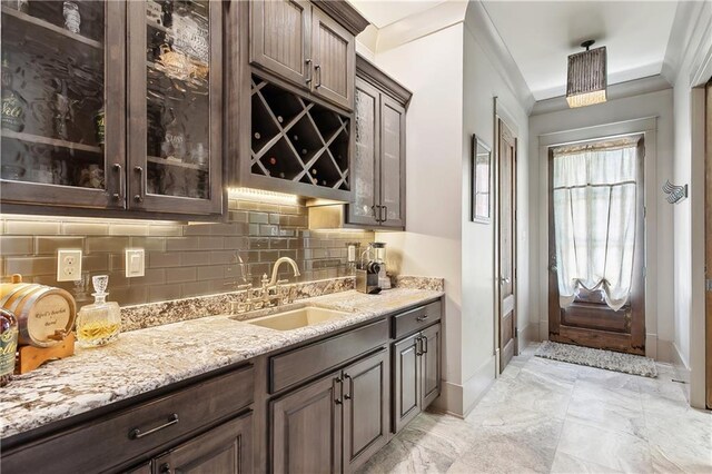 500 Tallow Tree Dr, Madisonville, LA 70447 - bar with a sink, decorative backsplash, baseboards, light marble finish floors, and crown molding