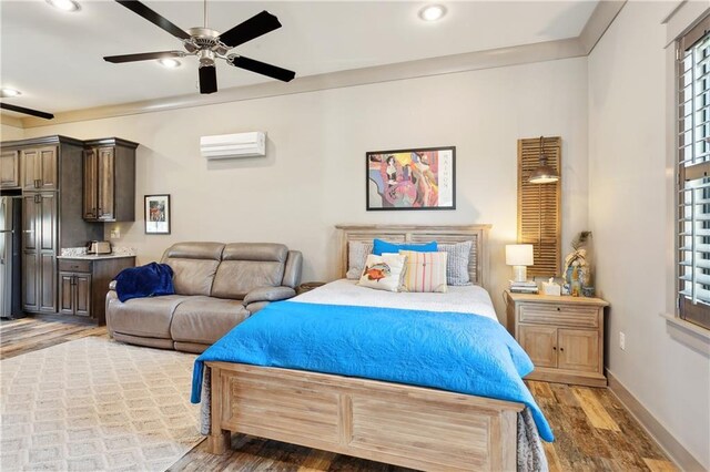 500 Tallow Tree Dr, Madisonville, LA 70447 - bedroom featuring a wall mounted AC, freestanding refrigerator, wood finished floors, recessed lighting, and baseboards