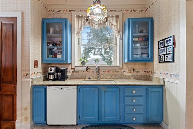 237 Villere Dr, Destrehan, LA 70047 - kitchen featuring dishwasher, blue cabinets, wallpapered walls, a sink, and glass insert cabinets