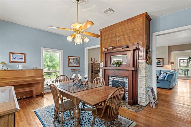 237 Villere Dr, Destrehan, LA 70047 - dining space featuring light wood-style flooring, ceiling fan, and a brick fireplace