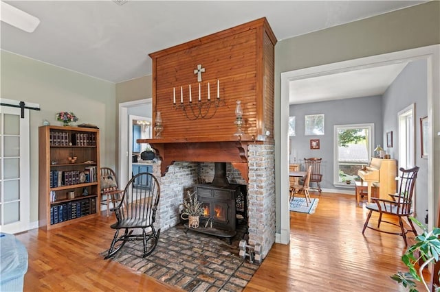237 Villere Dr, Destrehan, LA 70047 - living area featuring wood finished floors, a wood stove, and a barn door