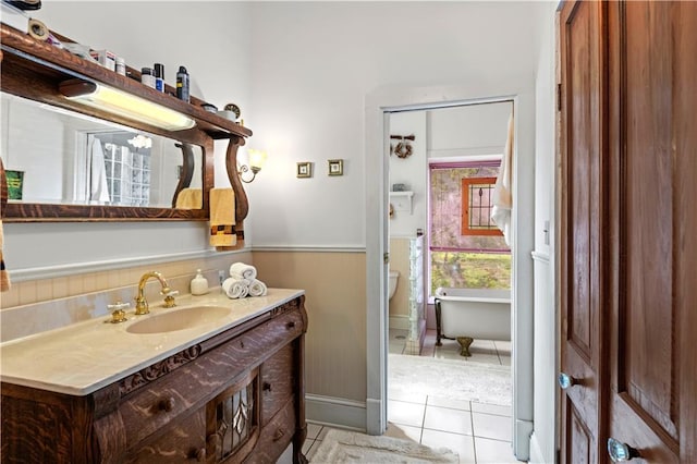 237 Villere Dr, Destrehan, LA 70047 - full bathroom featuring vanity, a freestanding bath, tile patterned flooring, and a wainscoted wall
