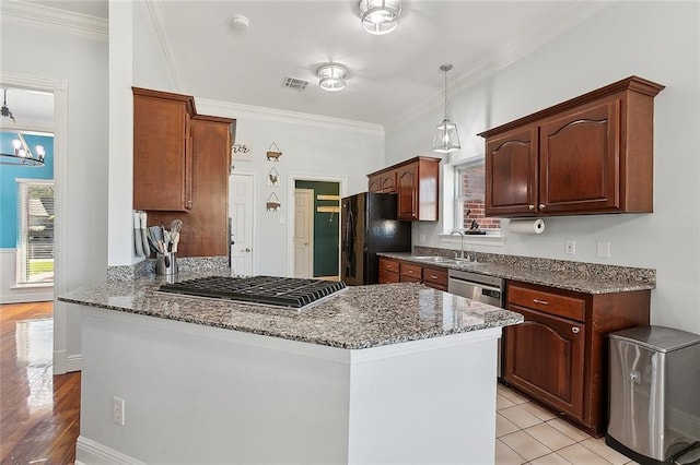 506 Doctor Gorman Dr, Belle Chasse, LA 70037 - kitchen featuring appliances with stainless steel finishes, a sink, dark stone countertops, a peninsula, and crown molding