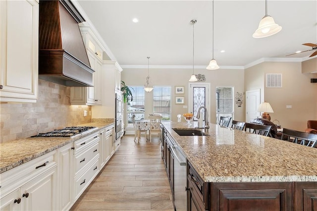5001 Randolph St, Marrero, LA 70072 - kitchen with a sink, stainless steel appliances, premium range hood, an island with sink, and tasteful backsplash
