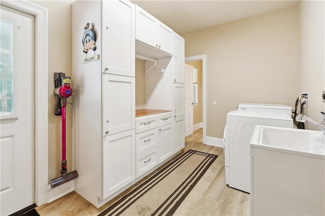 5001 Randolph St, Marrero, LA 70072 - washroom with cabinet space, separate washer and dryer, and light wood-style floors