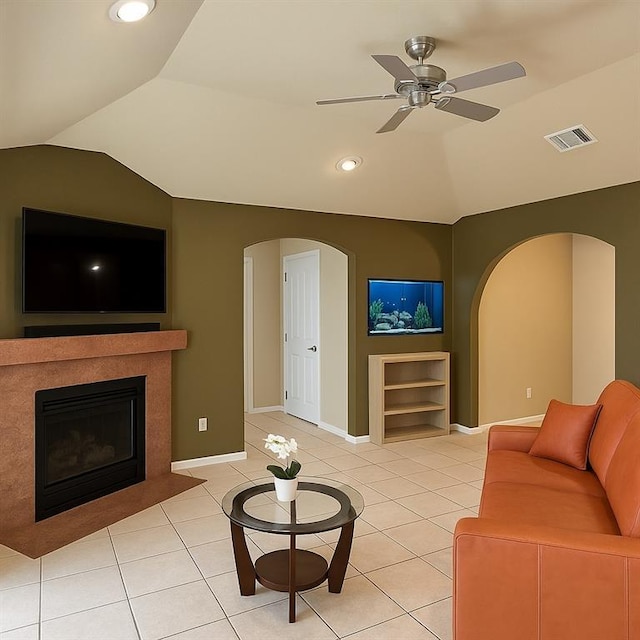 13801 Horizon Dr, New Orleans, LA 70129 - living area featuring vaulted ceiling, a ceiling fan, arched walkways, light tile patterned flooring, and a fireplace